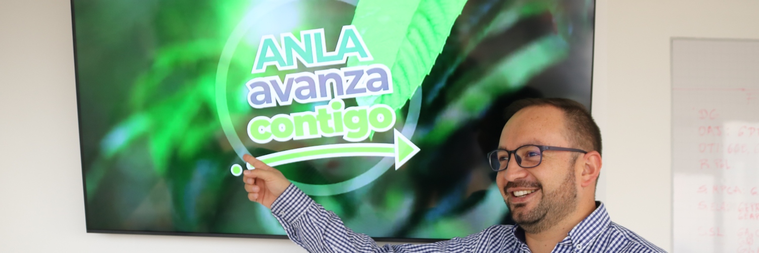 Imagen de funcionario señalando pantalla donde se ve el curso virtual de licenciamiento ambiental